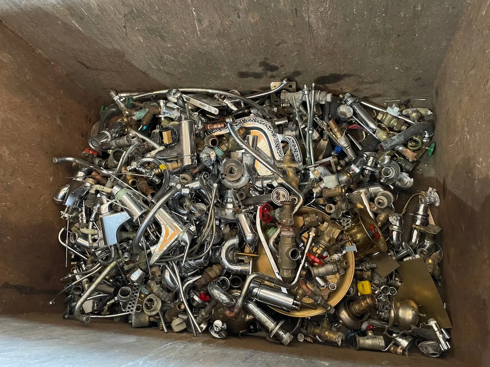 Container mit gesammeltem Altmetall, Messing- und Edelstahlteilen